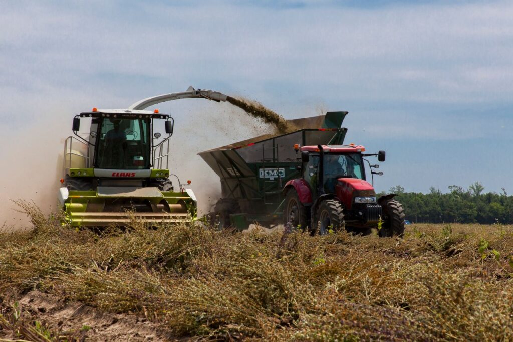 Tractors working in a field during harvest in rural North Carolina on a clear day.